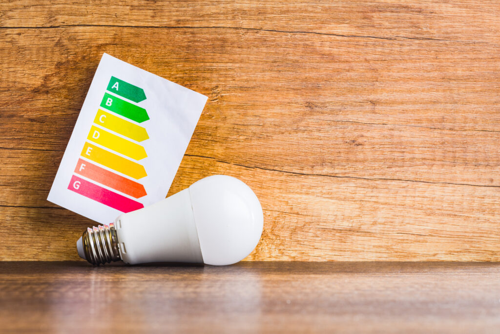 Ledlamp naast een energielabel van A tot G, symbool voor energiebesparing en hogere woningwaarde door een energielabelsprong